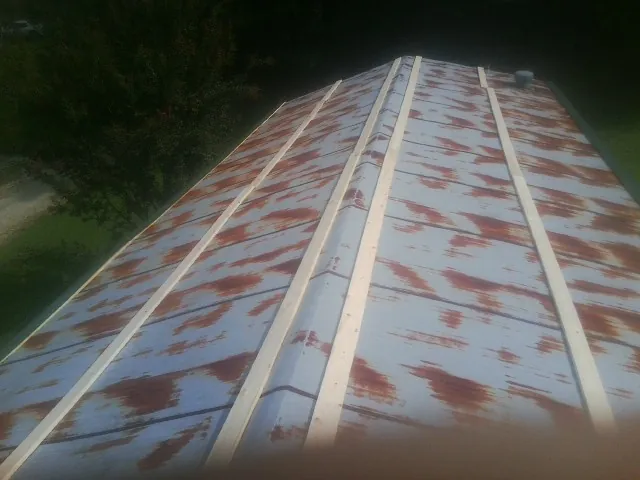 Rusted metal roof panels with new wood purlins before replacement — Storm Damage Roof Repair in Cottondale by Roofing Brothers